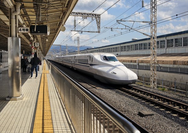 Shinkansen high-speed train travels through Mishima Station