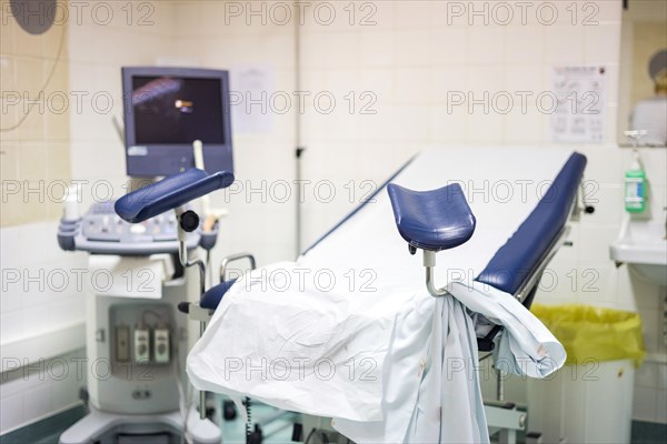 Navy blue gynecological chair with ultrasound monitor in the hospital