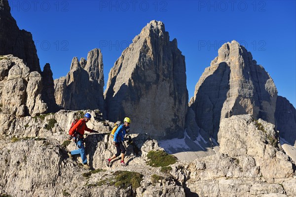 Hikers on the ascent to Paternkofel with a view of Three Peaks