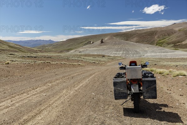 Heavily packed motorcycle on a gravel road in the desert