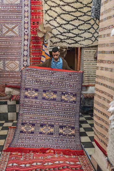 Carpet dealer shows a Moroccan carpet