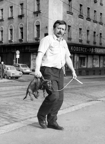 Man wears a dachshund on his neck ca. 1970s