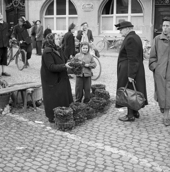 Older woman and boy sell flower wreaths