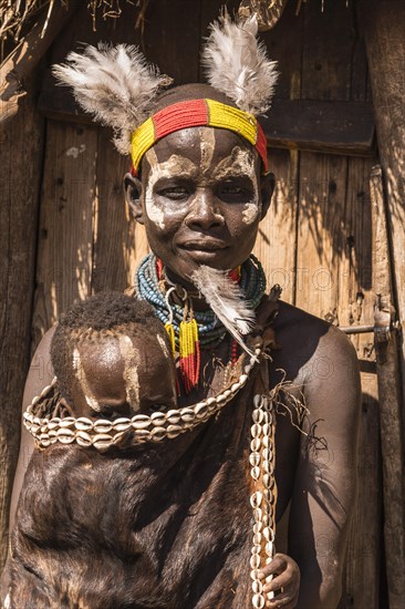 Young woman with toddler in traditional clothes made of goatskin