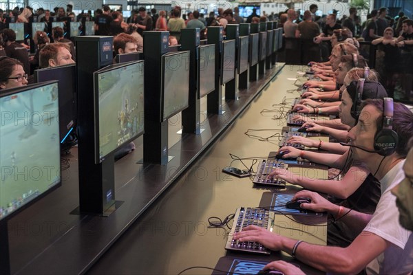 Visitors playing the computer game World of Warcraft in front of screens