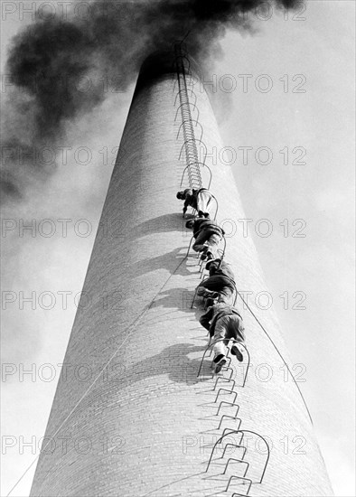 Four men climb up a chimney in a row