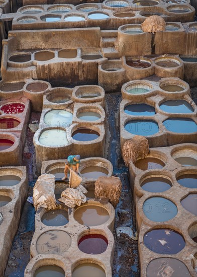 Worker dyeing leather