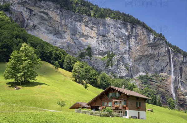 View of a farm house near Lauterbrunnen and with Staubbach Falls in the background