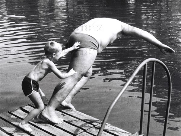 Boy throws man in the water ca. 1970s
