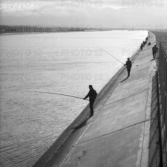 Men standing on the banks of a river and fishing