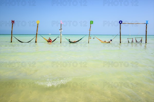 Tourists in hammocks on a beach