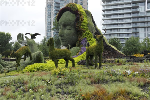 Plant sculpture Mother Earth with modern buildings behind