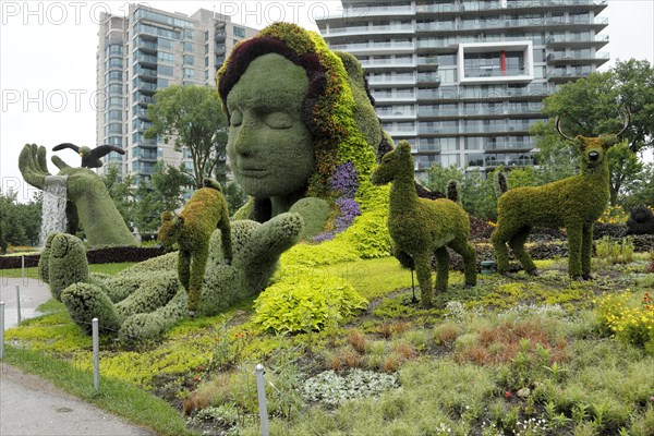 Plant sculpture Mother Earth with modern buildings behind