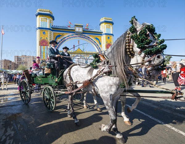 Decorated horse-drawn carriage in front of illuminated entrance gate