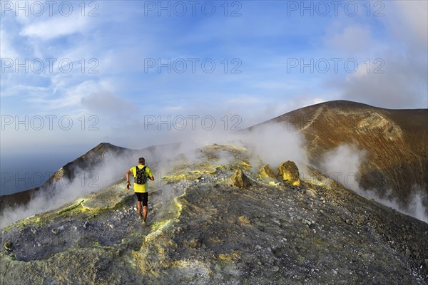 Trailrunner surrounded by sulfur fumaroles and chloride crusts on the crater rim