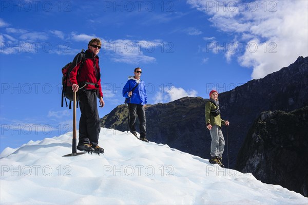 Tourists standing on the icefield of the Fox Glacier