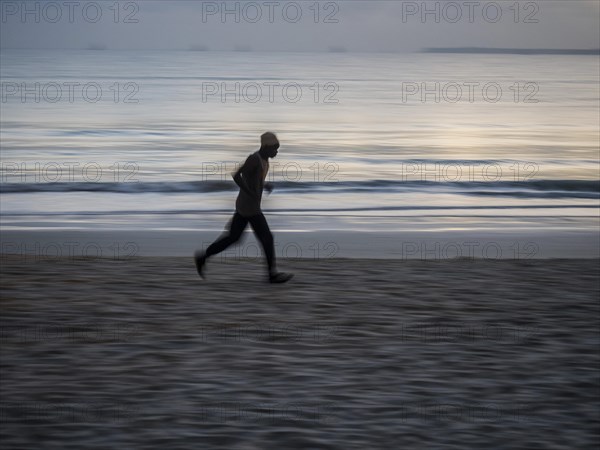 Local athlete doing morning exercise at dawn on the beach at Dar es Salaam
