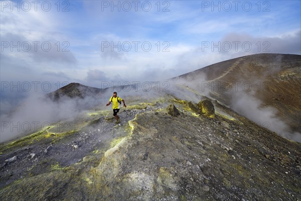 Trailrunner surrounded by sulfur fumaroles and chloride crusts on the crater rim