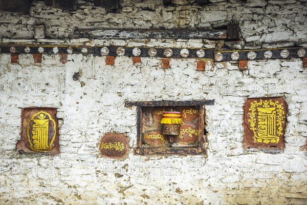 Mural painting and prayer mill on the monastery wall