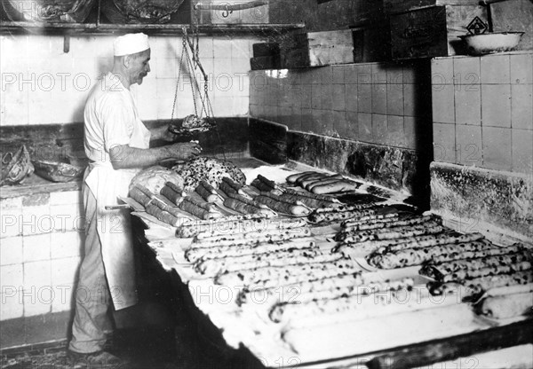 Baker bakes Dresden Christstollen ca. 1930