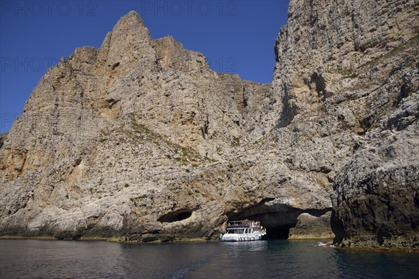 Tourist boat entering the sea cave Grotta Perciata