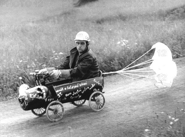 Man in soapbox with brake parachute ca. 1970s