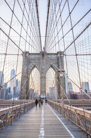 Walking in the evening light over the Brooklyn Bridge