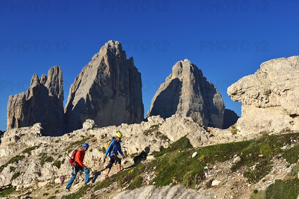 Hikers on the ascent to Paternkofel with a view of Three Peaks