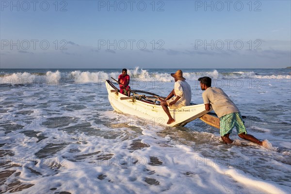 Fishermen in the boat in the surf