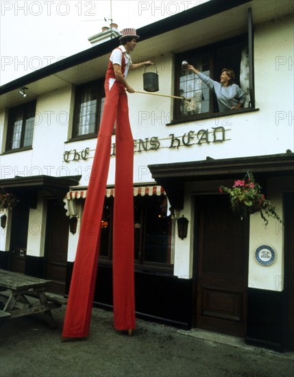 Man on stilts cleaning windows