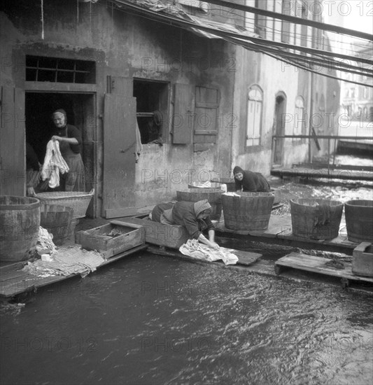 Housewives do their laundry on the banks of a river