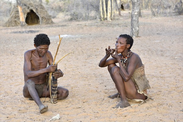 San man with bow and arrow and smoking woman