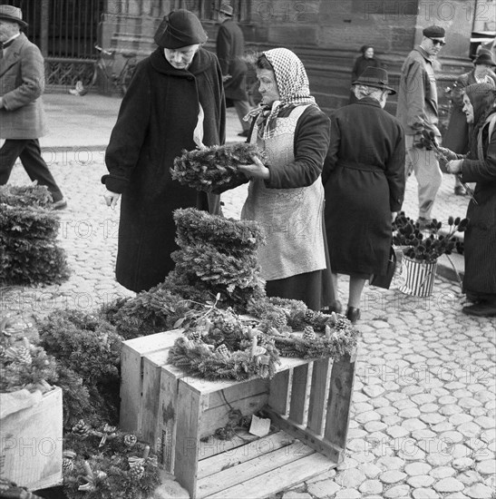 Woman sells her flower wreaths on the market square