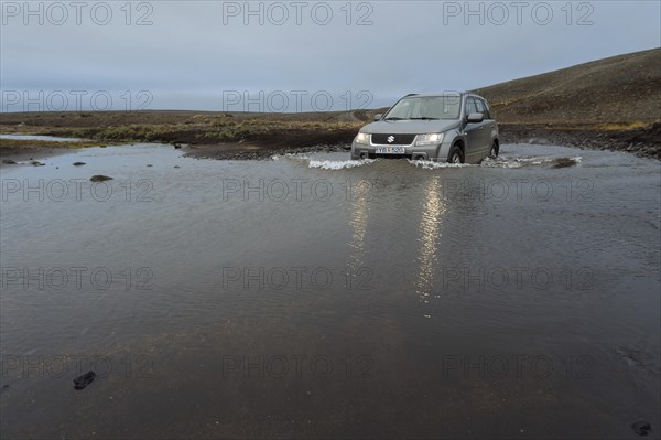 Off road vehicle drives through waterfurt