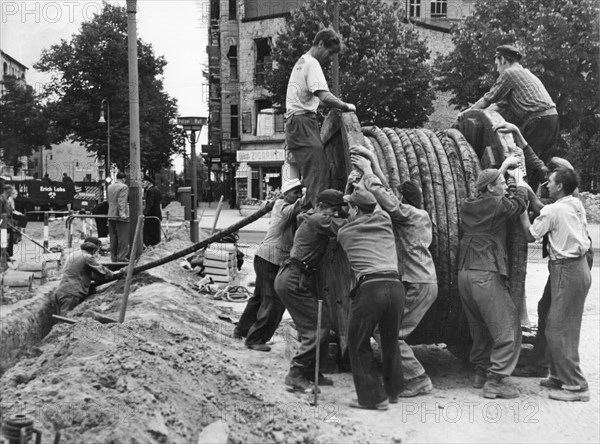 Men with huge cable reel on construction site