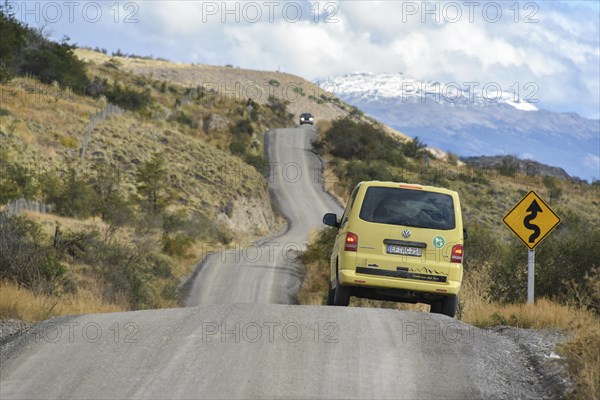 Yellow travel minibus on the Carretera Austral at Cochrane at road sign