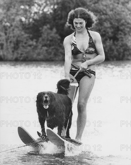 Woman with dog rides water ski