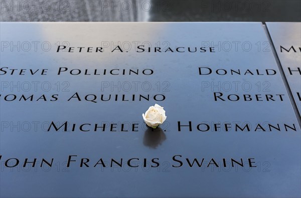Names of 9/11 victims on pool parapet with white rose
