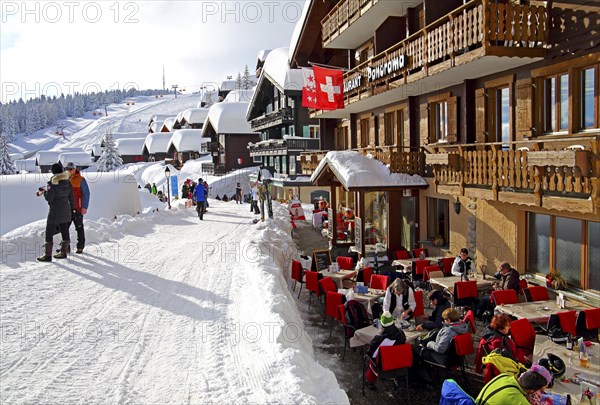 Restaurant terrace on the Dorfstrasse with snow-covered houses