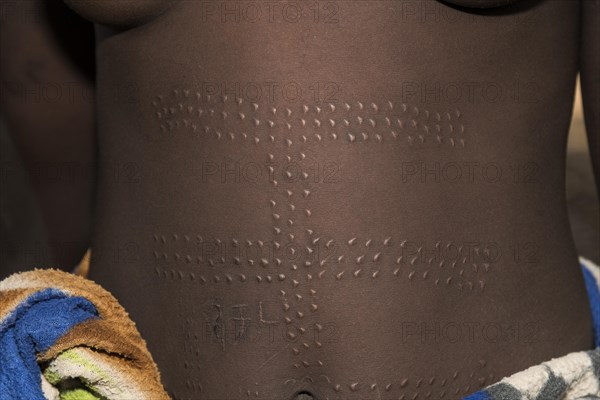 Young woman with ornamental scars on the belly