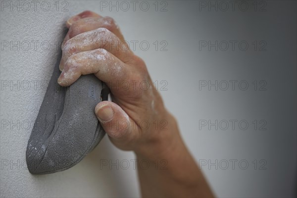 A hand holding on to an artificial climbing grip