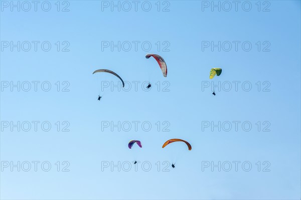 Paragliders in a blue sky