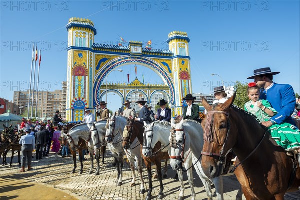 Rider on decorated horses with traditional clothes in front of lighted entrance gate