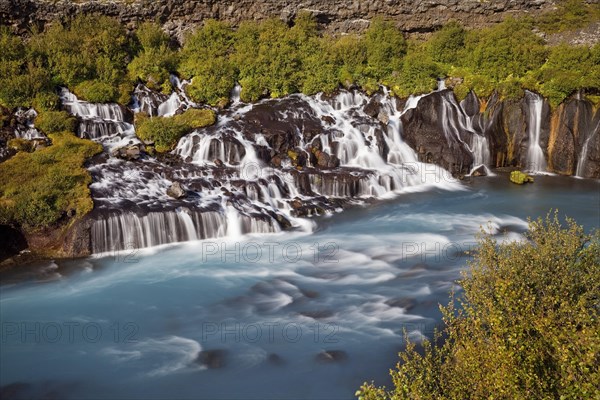 Waterfall Hraunfossar with the blue river Hvita