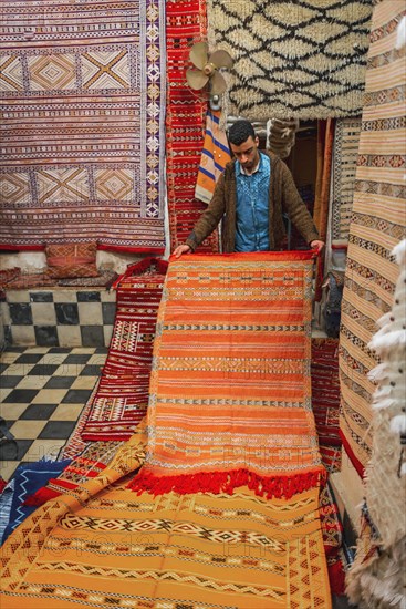 Carpet dealer shows a Moroccan carpet