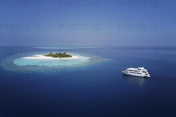 Diving safari ship MS Keana anchors off uninhabited palm island