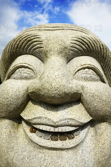 Ebisu Buddha with coins in his mouth