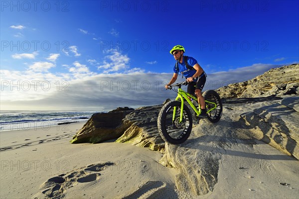 Mountain biker with fat bike on the beach