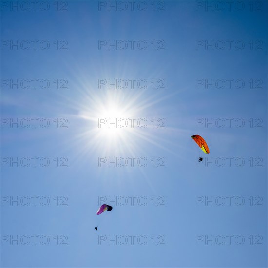 Paragliders in a blue sky