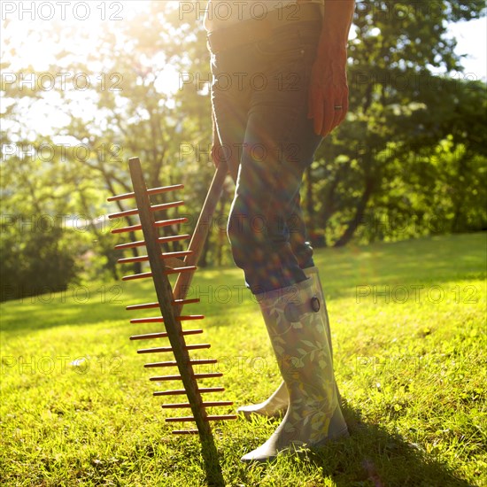Woman gardening with a fork and gumboots